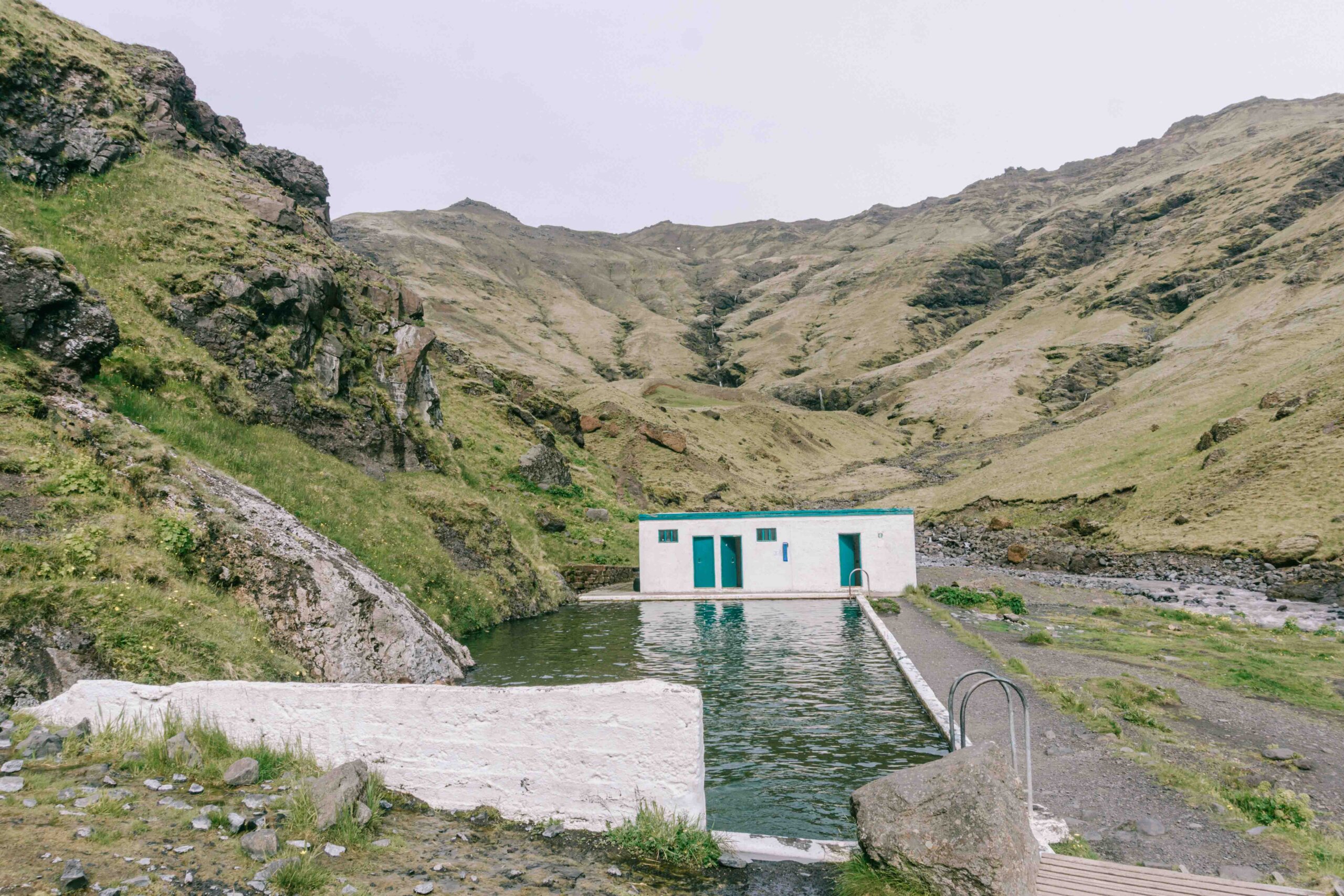Make sure to stop for a swim at Seljavallalaug one of Iceland’s oldest hot spring pools, that's surrounded by mountains during your Iceland Road Trip